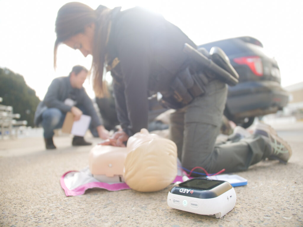 Police and AEDs, officer uses Avive Connect AED in CPR training.